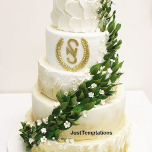 gold and white wedding cake with leaves
