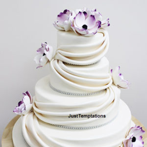white wedding cake with prurple flowers
