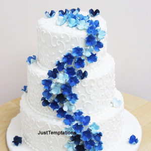 3 tiered white wedding cake with blue flowers