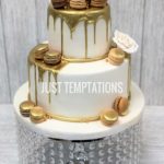 white and gold wedding cake with macaroons